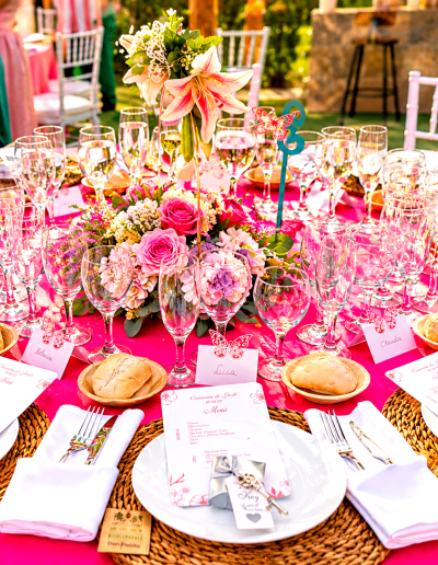 Mesa de boda fucsia con flores y cristalería